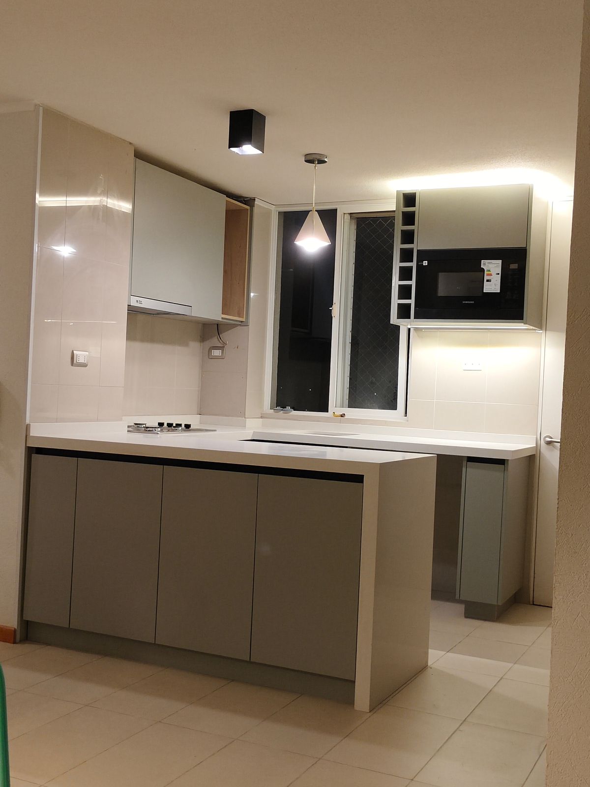 Departamento — cocina compacta con vitrinas de vidrio e iluminación cálida, Vanturia